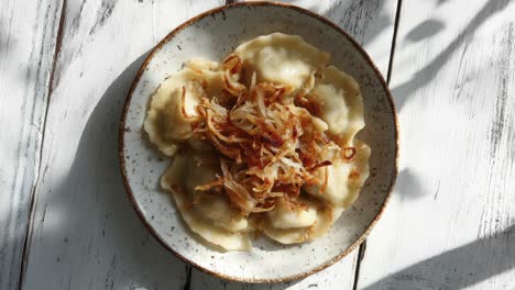 deliciosos pierogi en un plato rústico con cebollas fritas