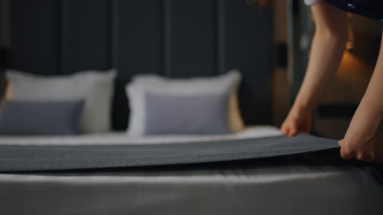 호텔 하녀가 고급 호텔 방에서 침대를 니다.