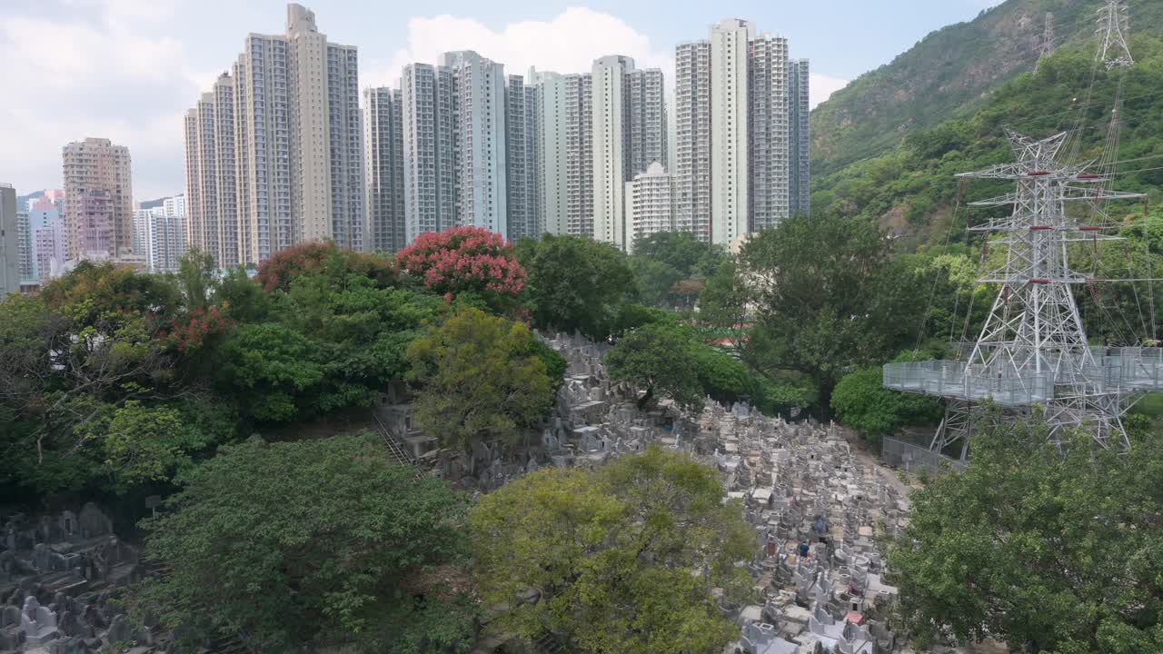 View of a crowded cemetery as residential buildings are seen in the background during the Chung Yeung Festival when people visit deceased relatives' graves in remembrance and respect
