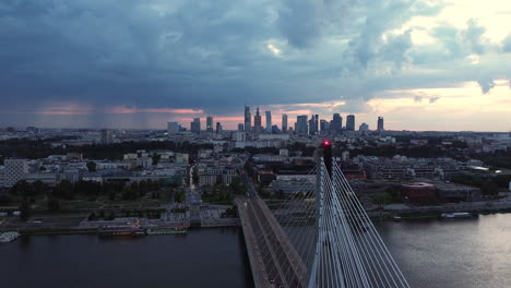 orbit drone shot of holy cross bridge and cityscape at sunset in warsaw, poland