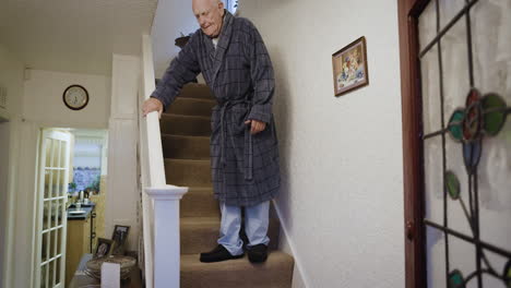 elderly man carefully walking down the stairs at home
