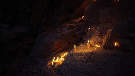 candles illuminate rocky path at dusk near serene natural setting