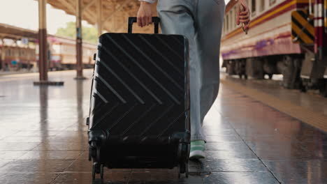 woman with luggage at train station