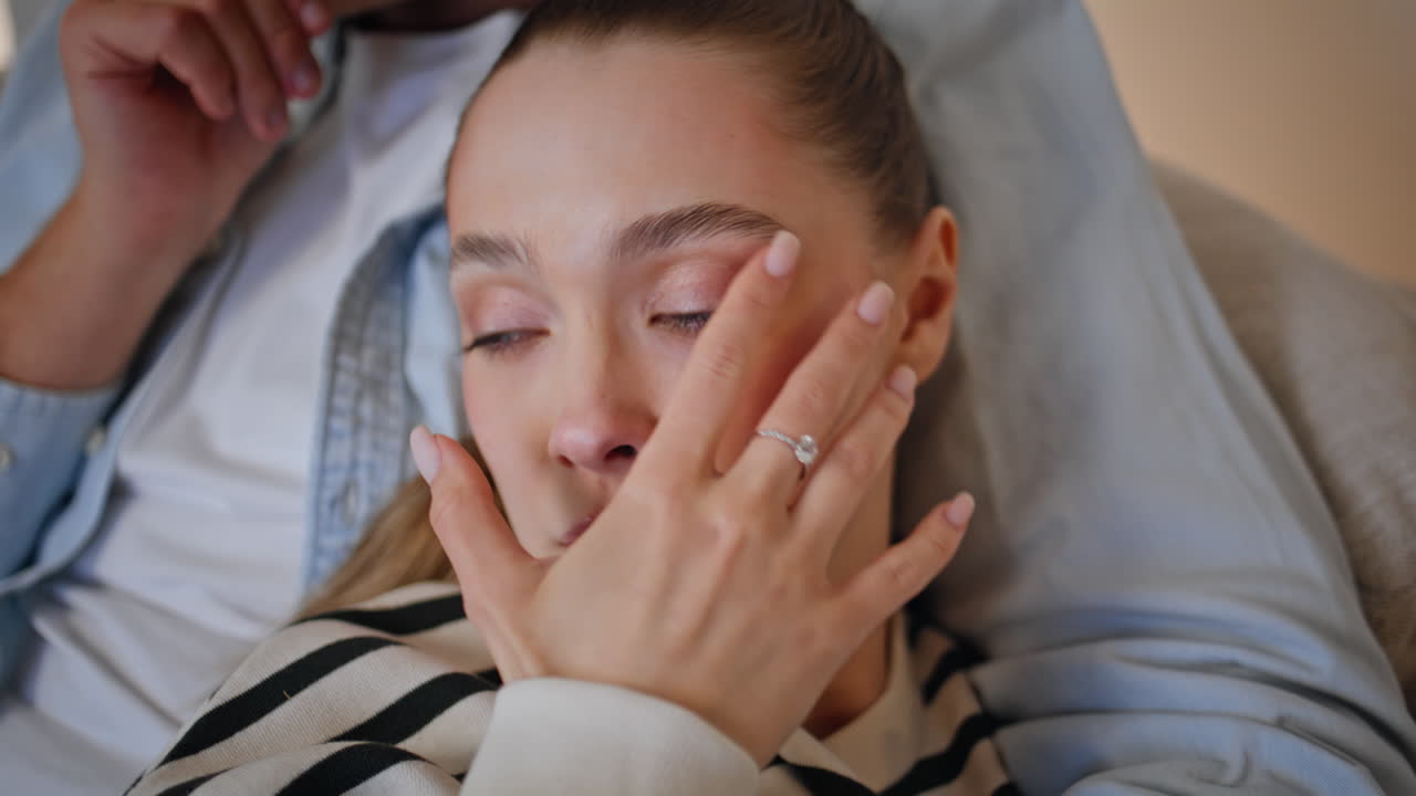 Closeup wife watching television leaning on husband shoulder at evening home