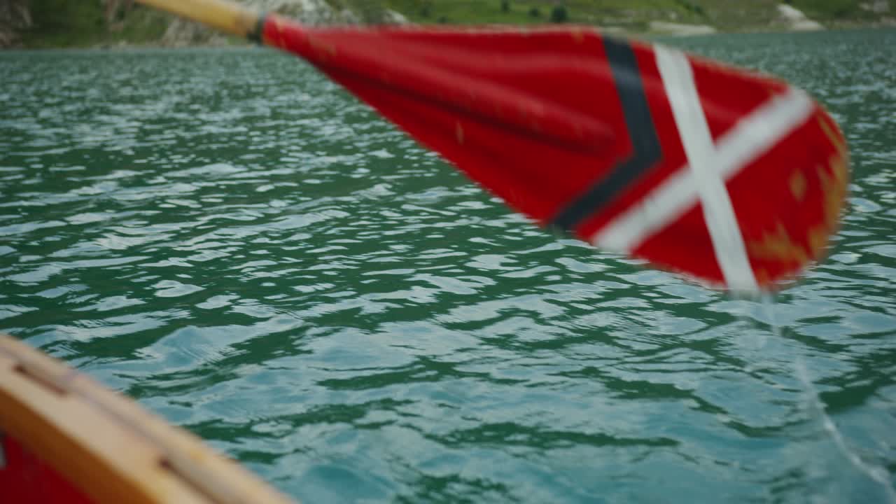 lago tranquilo con un barco de madera y una paleta roja