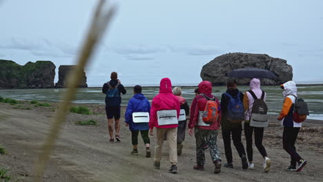 group hiking on a rainy coastline