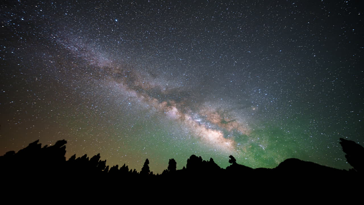 Majestic view of the Milky Way galaxy and silhouette of volcanic rock formations at Mirador Llano de Jable, La Palma, timelapse