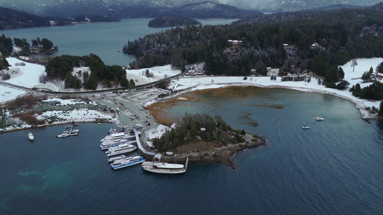 Veduta aerea della marina di Puerto Pañuelo a Bariloche con leggera nevicata, barche e il paesaggio lacustre patagonico