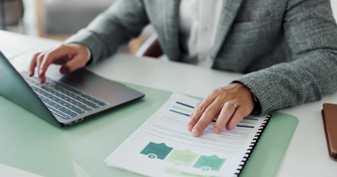 Professional Man Working on Laptop and Reviewing Business Documents