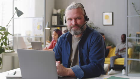 Portrait-of-Senior-Call-Center-Agent-in-Headset-at-Work