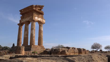 Panning-with-landscape-of-ancient-Tempio-dei-Dioscuri-or-Tempio-di-Castore-e-Polluce-temple-in-Valley-of-the-Temples-in-Agrigento,-Italy