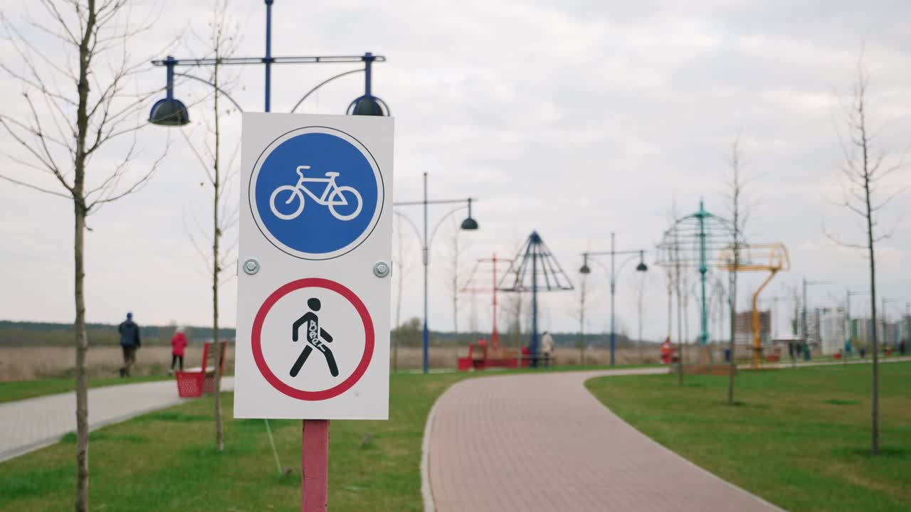 Bike route road sign against cycle path and promenade. Bicycle lane singpost. Bikeway in playground. Cycleway signboard. Cycling symbol. "No pedestrian" road sign