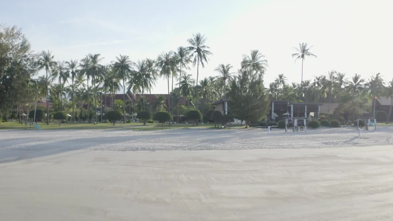 vista total tiro de seguimiento playa sobre árboles, edificios y colinas, sin gente, luz del día, cielo soleado, paisaje