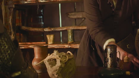 el caballero cambia el botín en monedas en la vieja tienda de comerciantes de primer plano. el vendedor sorprendido da un bolso con dinero para los trofeos de batalla del asesino en la tienda. vida medieval