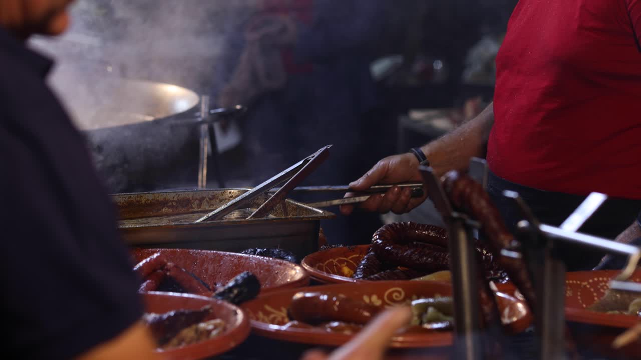 Street Food. Pork and Portuguese traditional spicy sausages being cooked over hot charcoal fire