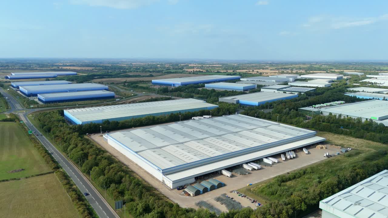 Filmato aereo di un drone che mostra il polo logistico Magna Park di Lutterworth, in Inghilterra (Regno Unito), con magazzini, fabbriche e centri di distribuzione al tramonto in una sera d'estate