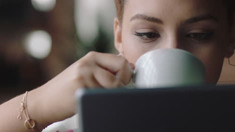 Cerrar-Una-Hermosa-Joven-Estudiante-De-Raza-Mixta-Usando-Una-Tableta-En-Una-Cafetería-Tomando-Café-Navegando-En-Línea-Leyendo-Mensajes-En-Las-Redes-Sociales-Disfrutando-Compartiendo-Un-Estilo-De-Vida-Relajante