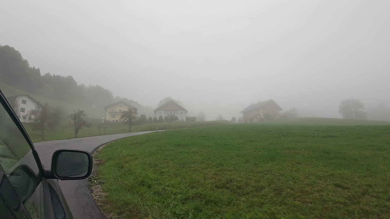 외로운 운전자는 안개가 가득한 길을 따라 신비로 뒤인 마을에 접근합니다.