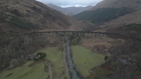 glenfinnan viaduct in scotland with surrounding landscape, overcast weather, aerial view