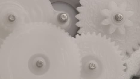five plastic gears rotate in mutual mesh inside a small reduction gear