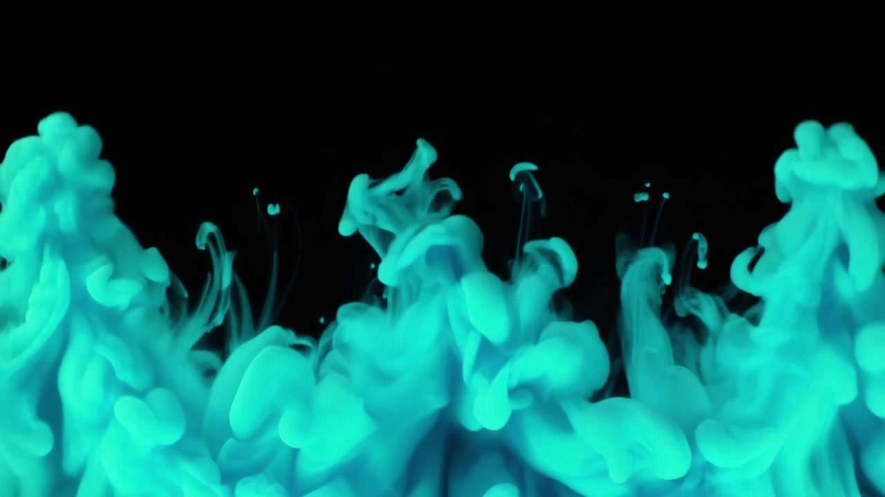 Nuages d'encre turquoise tourbillonnant dans l'eau sur fond noir