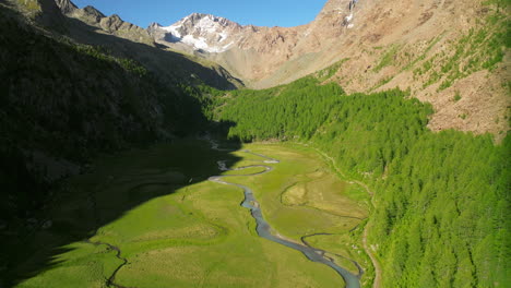 Llanura-De-Predarossa-Y-Río-Duino-Que-Fluye-En-La-Temporada-De-Verano-En-Val-Masino-Con-Montañas-De-Fondo,-Italia