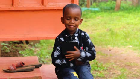 close-up of a young african boy playing on a tablet computer, child, kid,boy, african, ipad,device, tablet