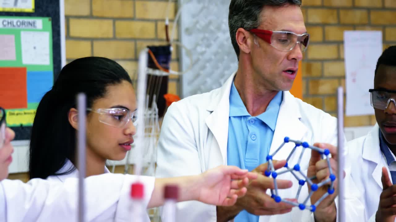 maestro de escuela ayudando a los escolares en el modelo molecular 4k