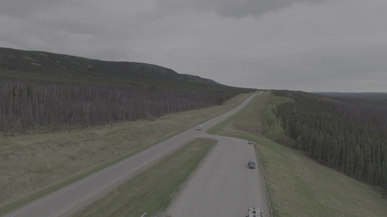 An RV drives along the remote and scenic Alaska Highway