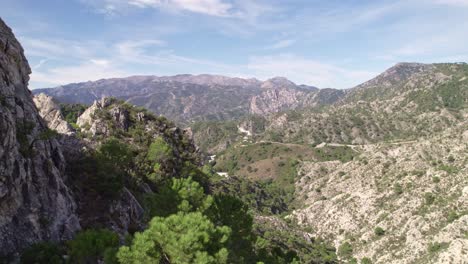 low level aerial view revealing high mountain peaks and mediterranean forest