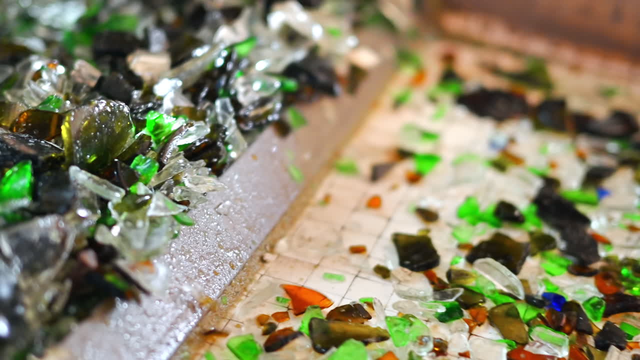 Process of sorting glass garbage on a vibrating conveyor belt at waste sorting plant. Slow motion