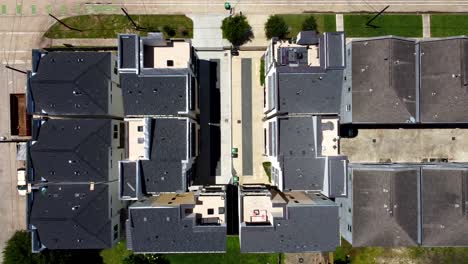 una vista aérea ascendente de condominios y unidades múltiples, en un día soleado