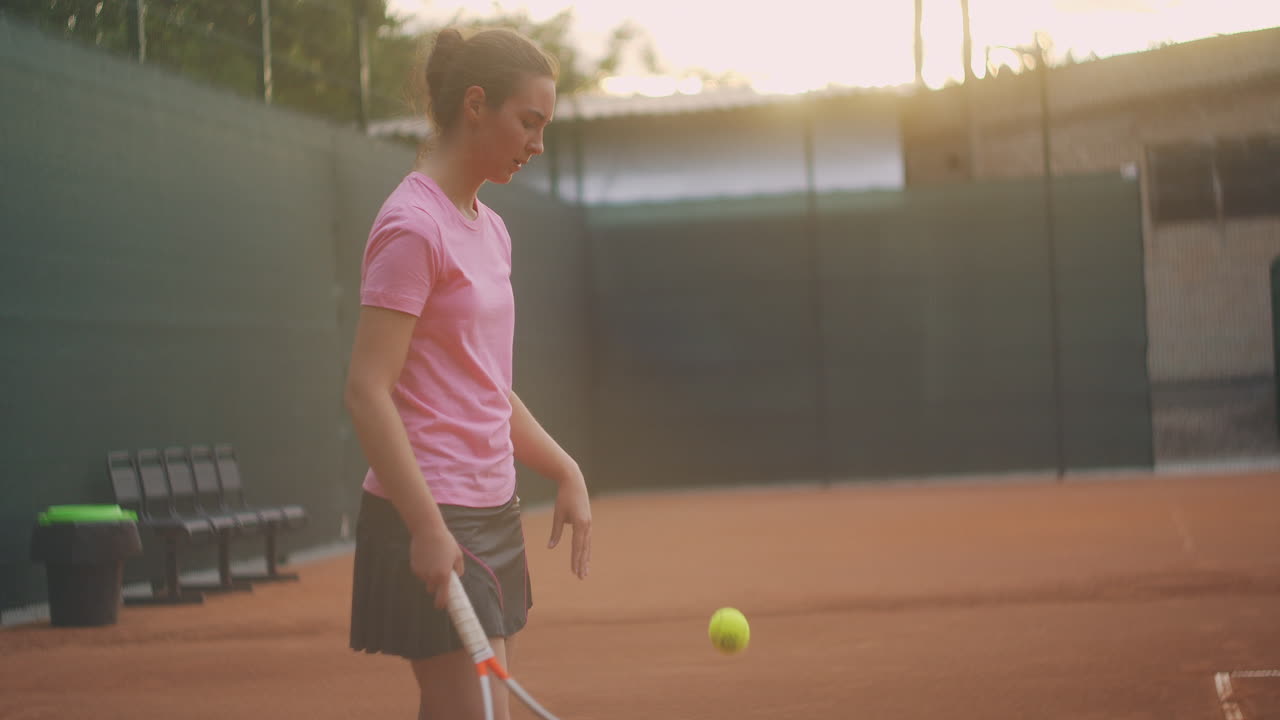 una jugadora de tenis en la cancha al atardecer después de un partido cansada mirando hacia adelante y concentrándose después de un juego duro