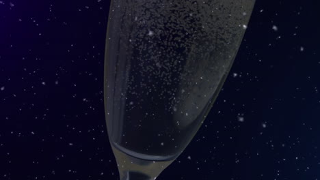 animation of falling confetti over glass of champagne on dark background