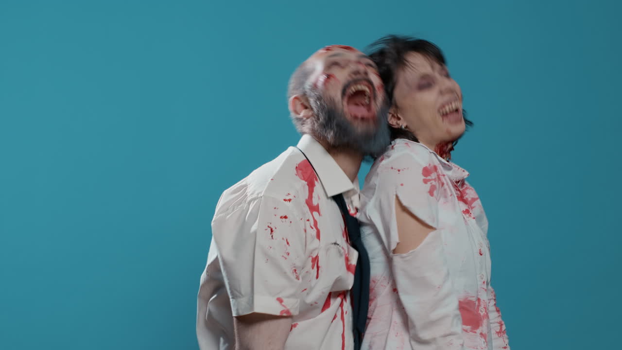Funny spooky looking zombies biting each other and acting playful in front of camera