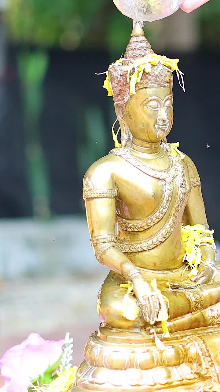 vertido secuencial de agua sobre una estatua de oro de buda