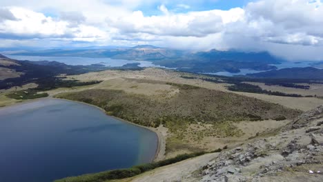 The-tranquility-of-towering-peaks,-lush-greenery-and-the-glistening-azure-waters-of-a-majestic-lake