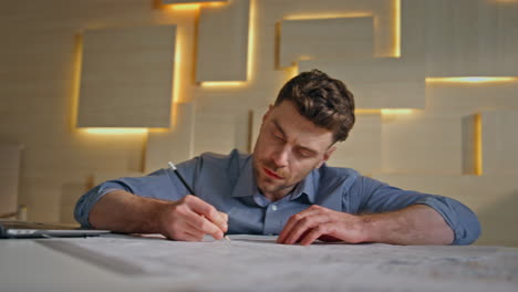 professional builder writing draft in modern architectural agency close up.