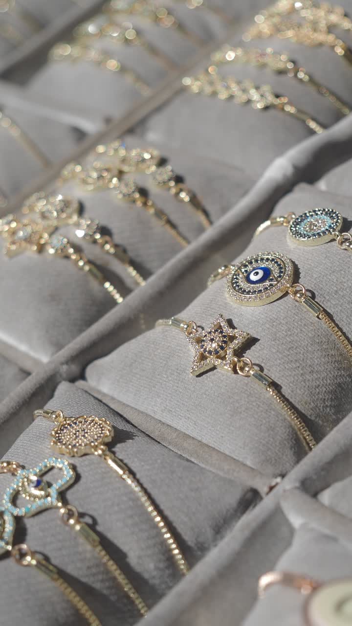 Pulseras de oro brillantes con dijes expuestas en un joyero