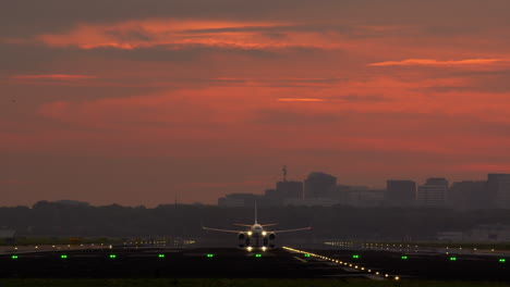 airplane taking off at sunset over city