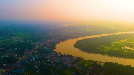 Scenic-aerial-landscape-of-small-town-beside-river-bend-at-sunset-in-Asia