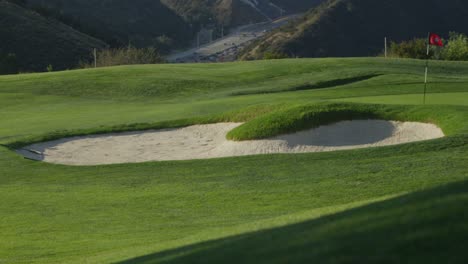 Weite-Sicht-Auf-Einen-Sandfang-Auf-Einem-Golfplatz-Mit-Bergen-Im-Hintergrund