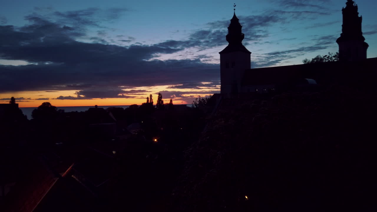 Silhouette of Visby Cathedral with two towers against dusk sky