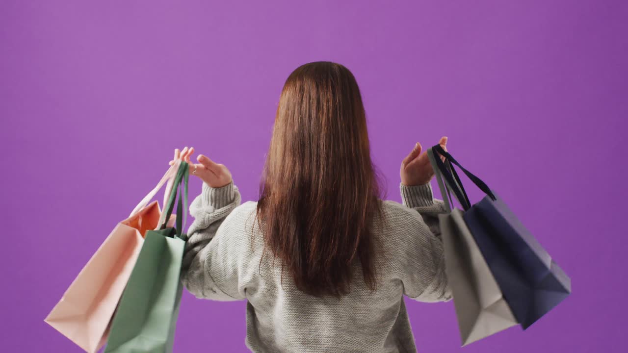 보라색 배경 에 검은색 과  ⁇ 색 의 선물 가방 을 들고 있는 여자 의 뒷면