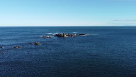 Volando-Hacia-Y-Sobre-Algunas-Rocas-Del-Océano-Hacia-El-Horizonte