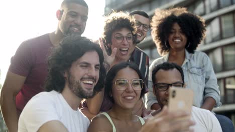 happy friends waving with hands to smartphone camera