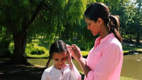 happy mother standing with her daughter in park
