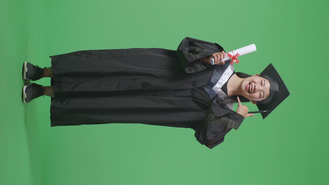 Donna in toga di laurea che tiene un diploma