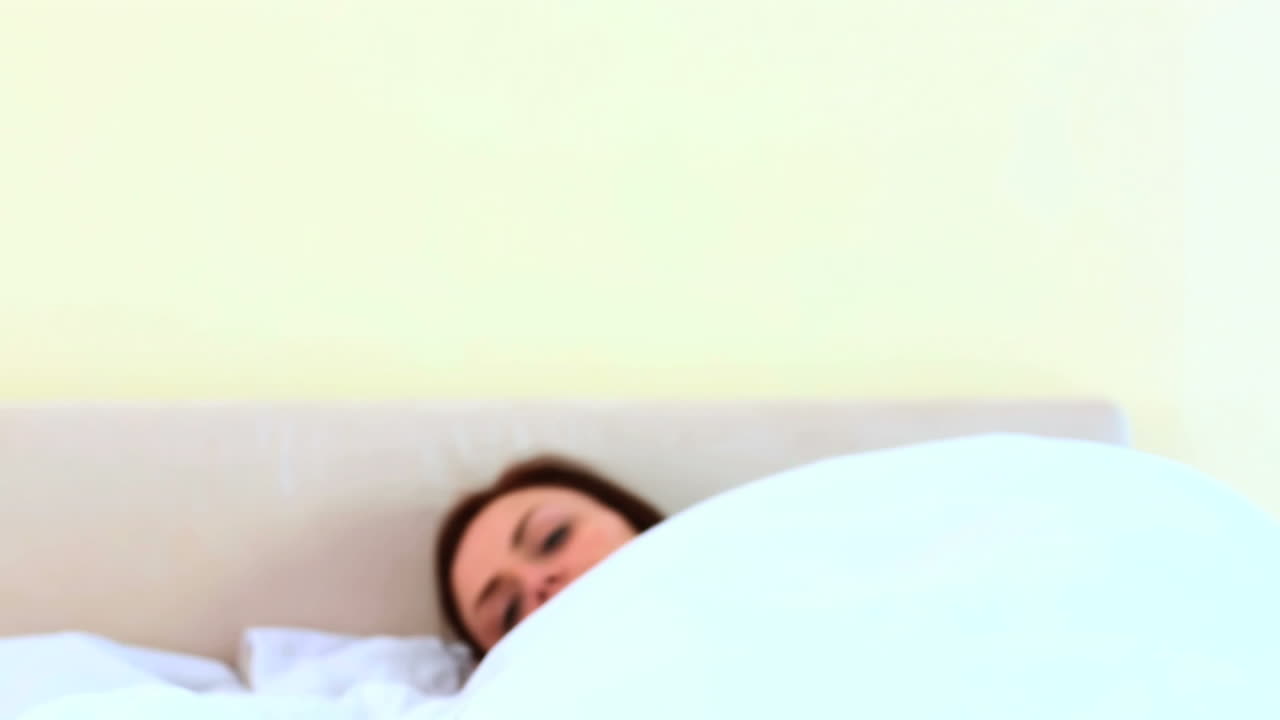 매력적인 여성이 침대에 가고 있습니다.