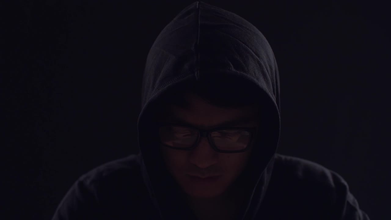 Asian Male Hacker Using Laptop Computer Hacking